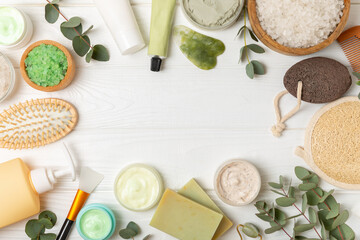 Beautiful spa composition on a wooden background with eucalyptus leaves. Beauty and fashion spa concept with body cream, scrub, mask, essential oil and sea salt.Cosmetic product. Copy space.