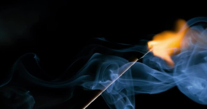 Burning matchstick close-up on a dark background. Shot on super slow motion camera 1000 fps.