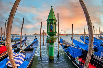 Poster  214 / 5.000 Resultados de traducción Resultado de traducción Venice at sunset, showing gondolas anchored in calm waters with a colorful sky as a backdrop. An ornate, green lighthouse in the middle © Juanma