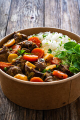 Takeaway food - roast pork with carrots and celeriac in sauce with white rice in lunch box on...