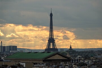 Vue panoramique sur le ciel de Paris en hauteur et la tour Eiffel avec rayons du soleil traversant les nuages	