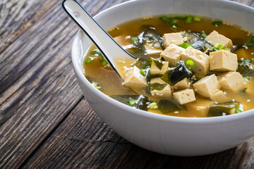 Miso soup - traditional Japanese soup with tofu on wooden table
