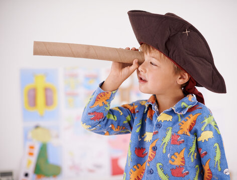 House, telescope or costume as pirate to play in fantasy in his bedroom with vision toy or creativity. Kid sailor, child captain or young boy in a game with pyjamas, hat or monocular to sail on bed