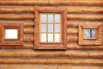 textured wall of a vintage log house with a window	