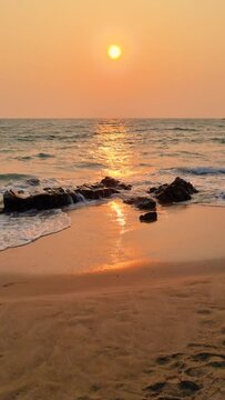 As the sun sets over the ocean, the sky and water blend into a stunning display of colors, creating a mesmerizing atmosphere on the beach of Koh Lanta Thailand