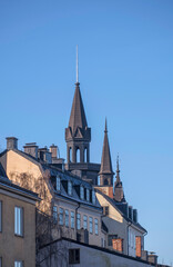 Facades tin roof with dorms, chimneys and towers in the district Mariaberget, a sunny winter day in Stockholm