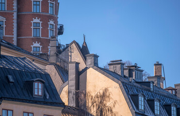 Facades tin roof with dorms and chimneys in the district Mariaberget, a sunny winter day in...