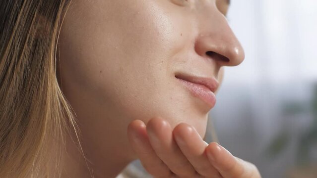 A girl woman massages her face using facial oil. Massages the chin. At home Beauty care. Close up