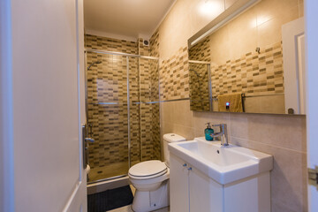 Spacious bathroom in gray tones with heated floors, walk-in shower, double sink vanity.