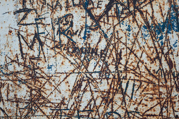 old, rusted, scratched, scratched metal surface with spray paint