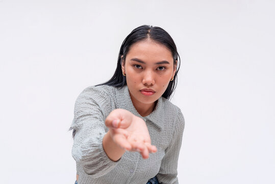 A demanding and uncaring young asian lady pressuring someone to give her money.