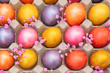 Easter colorful eggs decorated with small flowers arranged in cells. A family celebration. View from above.