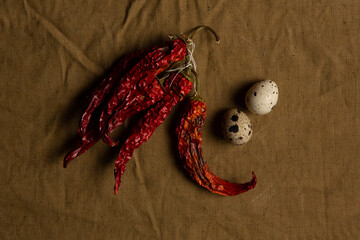 Food collage. Several dry hot peppers and two quail eggs