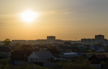 Evening landscape with village houses and multi-storey houses on the horizon sunset