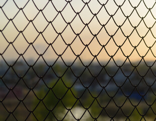Fototapeta premium Wire fence cells in the evening at sunset