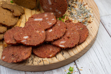 Seitan vegan Ham  and Peperoni, plant based. Sliced, on wooden board