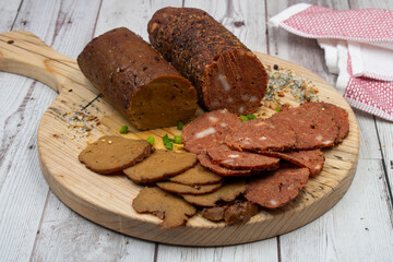 Seitan vegan Ham  and Peperoni, plant based. Sliced, on wooden board