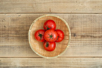 ザルに乗ったトマトとナチュラルな木材