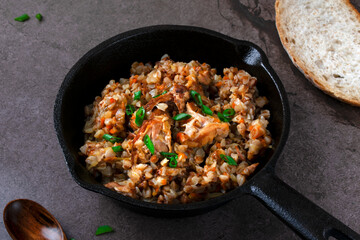 Meat with buckwheat served in the cast iron pan. Nutritious meal for lunch or dinner