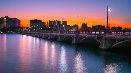 San Juan Sunrise Cityscape over Puente Dos Hermanos Bridge, opened in 19010, connecting Condado with Old San Juan crossing over the Condado Lagoon in Puerto Rico - obrazy, fototapety, plakaty