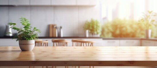 A wooden table in a modern, clean kitchen setting features a potted plant placed neatly on top. The...