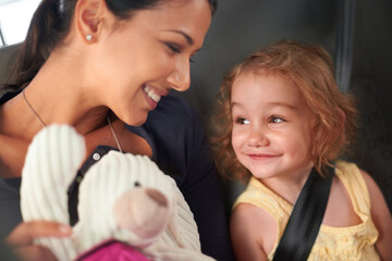 Taxi, love or mother and daughter in a car for adventure, road trip or bonding with teddy bear games. Happy, family and kid with mom in a backseat of cab with care, trust and safety, travel or fun