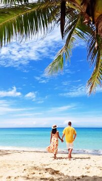 The man and woman are strolling along the azure beach holding hands, with the blue sky and tranquil water as their backdrop. A picturesque scene of nature, captured in a photograph Koh Kood, Thailand