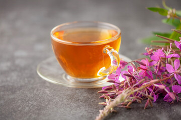 Herbal fireweed tea in a glass cup on the table. Alternative Medicine Concept