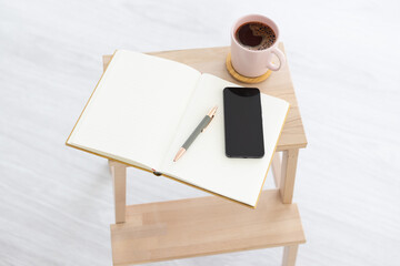 Notebook with pen, smartphone and coffeemug
