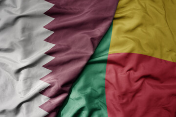 big waving national colorful flag of benin and national flag of qatar.