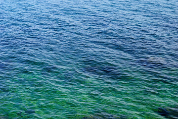 A view of the wavy sea surface of turquoise and blue color