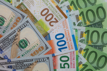 Obraz premium Closeup of 50, 100 and 200 Swiss franc banknotes and 100 euro and 100 dollar banknotes