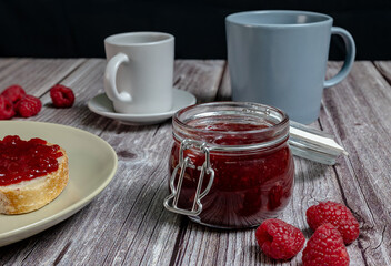Homemade raspberry jam in glass jar, healthy breakfast with toast and raspberry jam