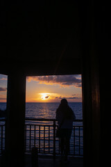 Silhouette of a woman at sunset on a gazebo by the beach. Portrait. Bil-At Point, Ferrol, Romblon,...