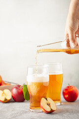 Boozy Refresing Cold Hard Apple Cider in a Pint Glass and Bottle on wooden table. Copy space