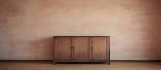 A wooden cabinet stands in the corner of an empty room, devoid of any other furniture or occupants. The room has plain walls and a simple, unadorned floor.