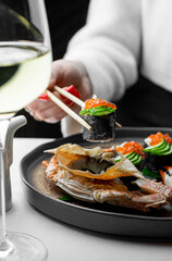 In an upscale restaurant, a beauty enjoys seafood, whiskey, and wine. Kamchatka crab and premium caviar elevate sushi. A tasty octopus is a treat. The bartender and sommelier expertly pair wines 