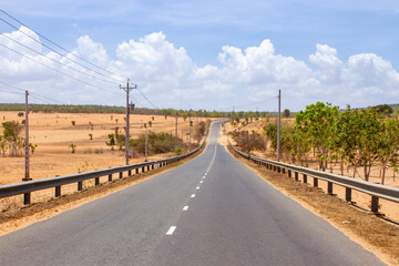 Fototapeta na wymiar A Countryside Road Through The Small Desert in Binh Thuan Province, Vietnam