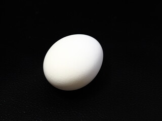 黒の背景に映える白い卵