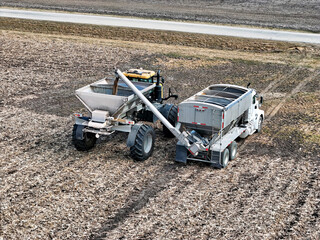 Self propelled spreader being loaded with fertilizer before appling to a field