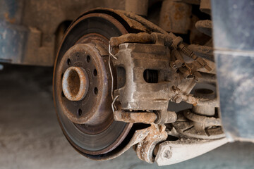 Car brake part in the garage, car brake disc without wheels. Car suspension. Current car repair