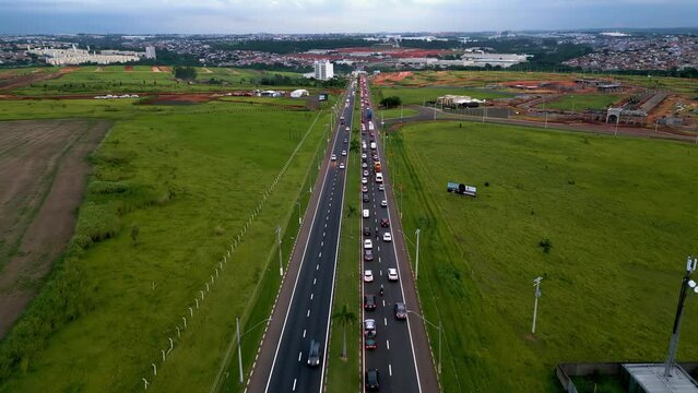 Tarde com tr&aacute;fego pesado de carros na cidade de Paul&iacute;nia, interior de S&atilde;o Paulo. Luzes de carros, final de tarde e c&eacute;u nublado.