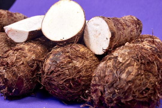 closeup of taro root vegetable, eddo malanga, purple background