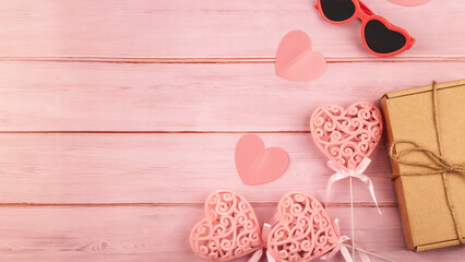 Romantic background. Wooden pink background with red hearts, gifts