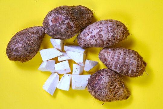closeup of taro root vegetable, eddo malanga, yellow background