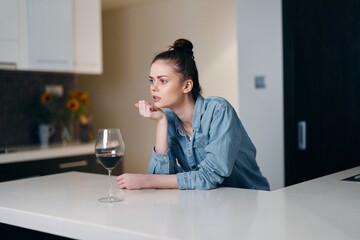 Lonely Caucasian Woman Holding a Glass of Wine, Captured in a Sad Portrait of Alcohol Addiction and Stress-Filled Lifestyle.