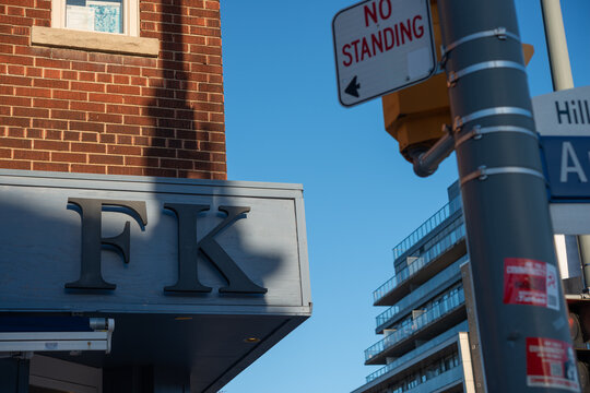 glancing up at the exterior sign of FK, a restaurant, located at 770 St Clair Avenue West in Toronto, Canada
