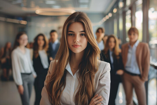 Young businesswoman standing in front of team. Group of business people in the background