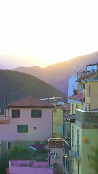 Early foggy morning in an alpine town. The rising sun illuminates the roofs of a medieval town in the mountains.. Perinaldo, Liguria, Italy.