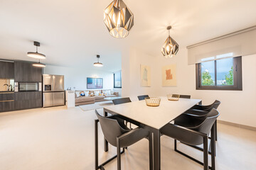 a dining table overlooking an open kitchen and living room in luxury mediterranean apartment